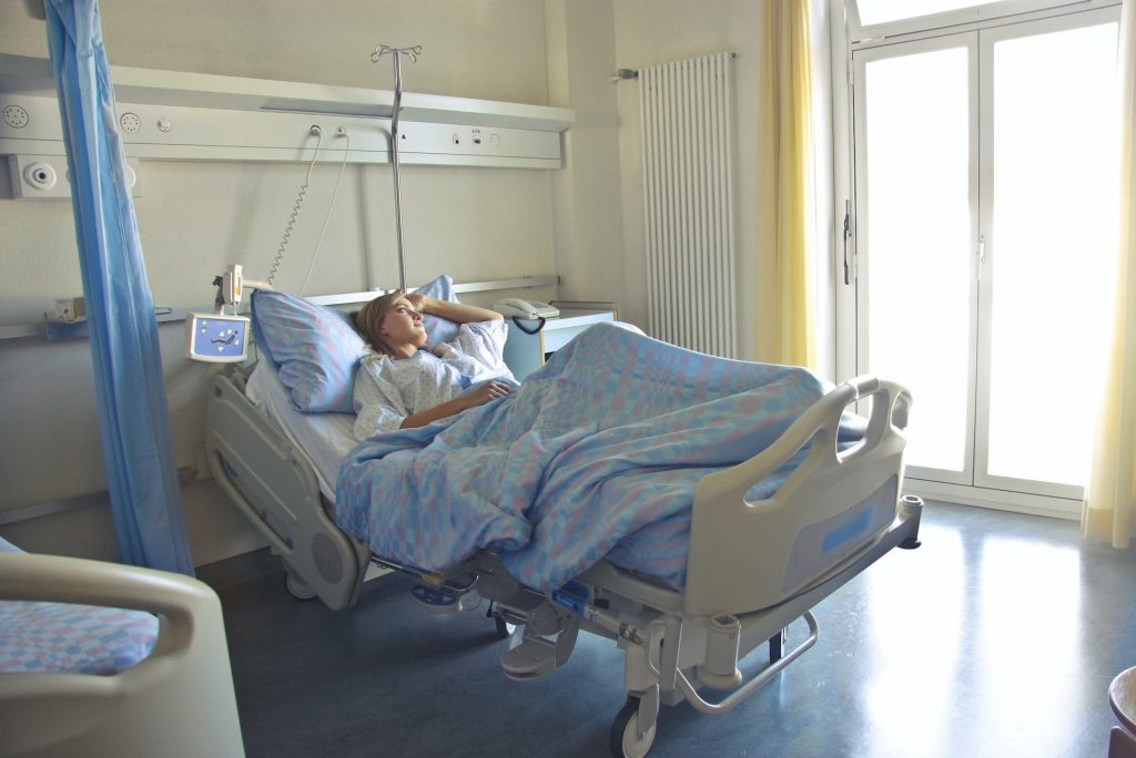 Woman lying in hospital bed staring out the window