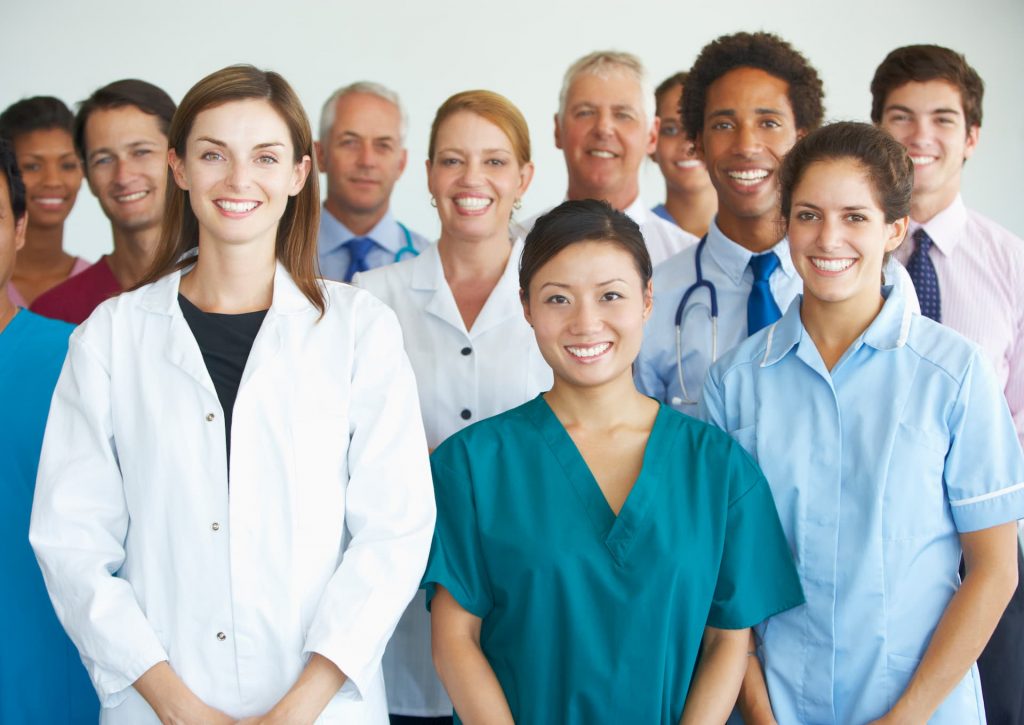 Group of diverse doctors, nurses and hospital staff standing in group photo