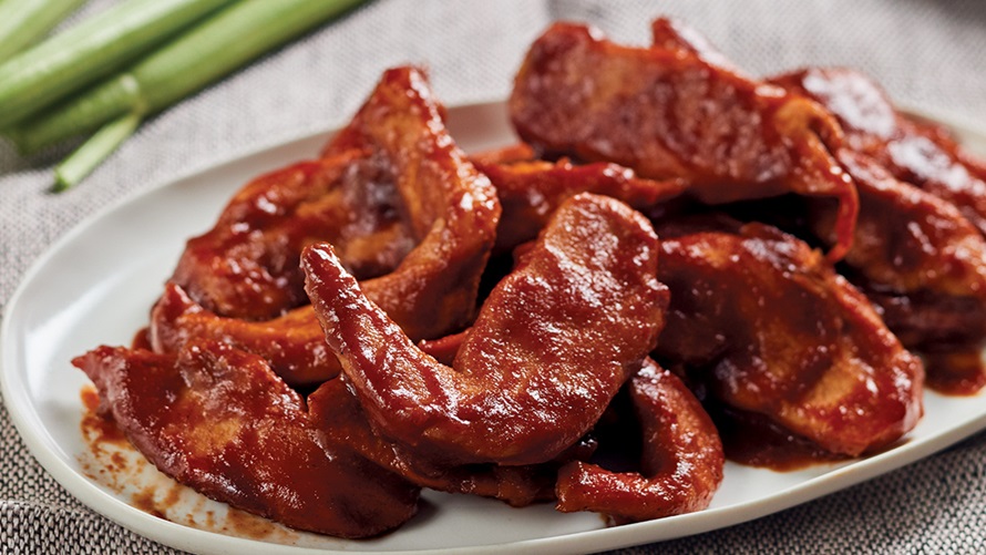Plate of bbq chicken wings covered in glazed cherry sauce