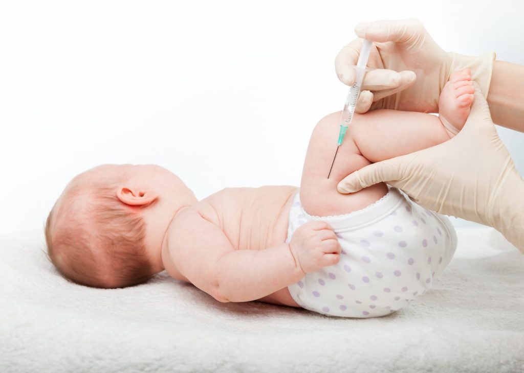 Infant getting shot in thigh; immunizations