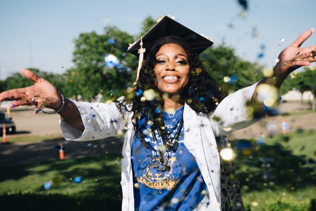 black nurse graduating from college, throwing confetti