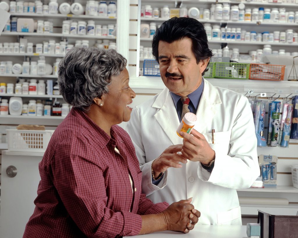 old black woman with hispanic pharmacist talking about medicine - talk to your doctor about hormones and breast cancer awareness