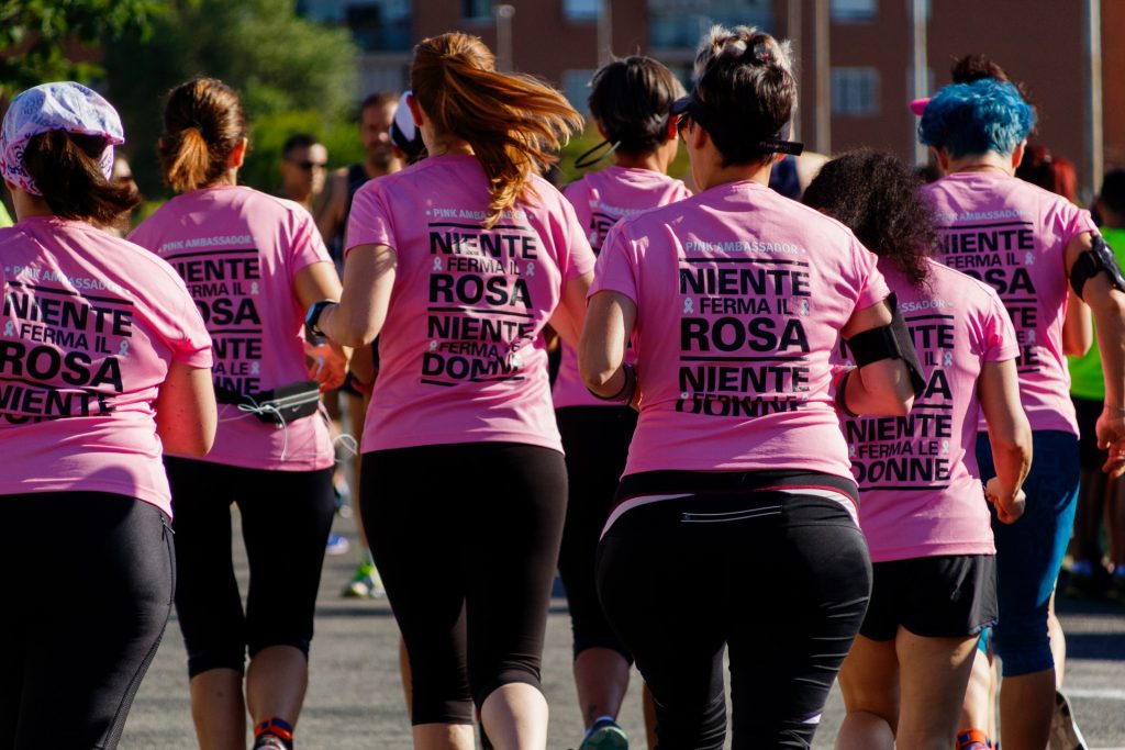 women running in breast cancer awareness marathon run with pink shirts